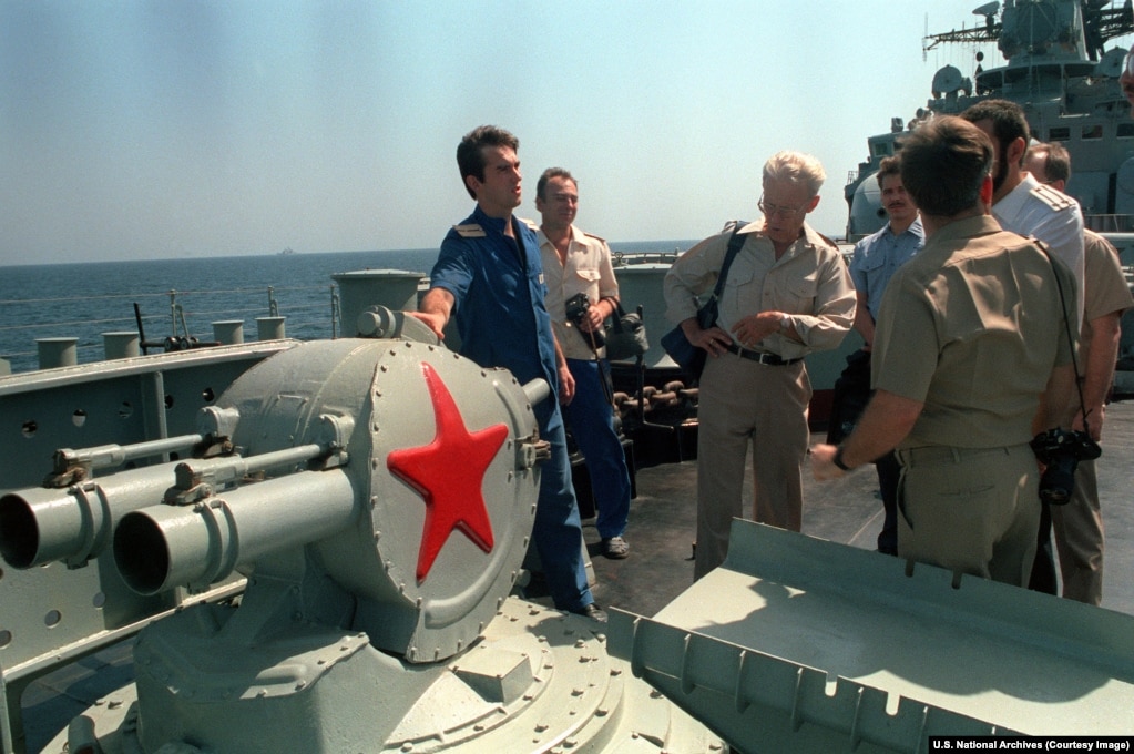 A Russian serviceman explains the operation of a chaff launcher, designed to baffle enemy radar to crew members from a U.S. aircraft carrier in October 1992.