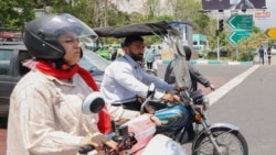 Egy férfi és egy nő motoron Teherán központjában