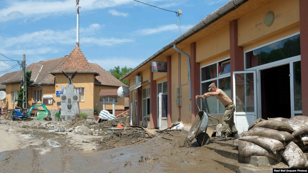 Locuitori si reprezentanti ai autoritatilor evalueaza pagubele si intervin in sprijinul localnicilor din Ocolis, Alba, dupa ce localitatea a fost inundata cu o zi inainte, 17 iulie 2021.