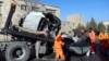 Afghan security personnel and municipality workers remove a damaged vehicle after a roadside bomb in Kabul on December 22.