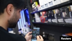 Iranac u Teheranu koristi svoj telefon poslije ponovnog otvaranja pristupa internetu, 27. maja 2026.