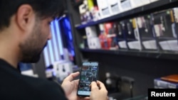 Iranac u Teheranu koristi svoj telefon posle ponovnog otvaranja pristupa internetu 27. maj 2026.

