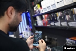 An Iranian man uses his phone after a reported reopening of international Internet access, in Tehran on May 27.