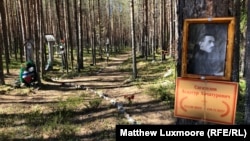 A portrait of a victim of Stalin's Great Terror is shown pinned to a tree at the Sandarmokh site.