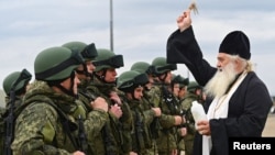 A priest sprinkles holy water on Russian reservists in the Rostov region who were recruited during the Kremlin's partial mobilization of troops before their departure to the Ukraine war zone on October 31.