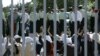 File photo - Iranian policemen stand guard in front of women clapping hands as they try to get into the stadium to watch the Asian qualifying match against Bahrain for World Cup 2006, in June 2005.