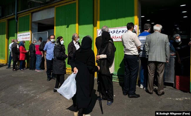 Люди в медицинских масках стоят в очереди за курицей в Тегеране. 5 апреля 2021 года