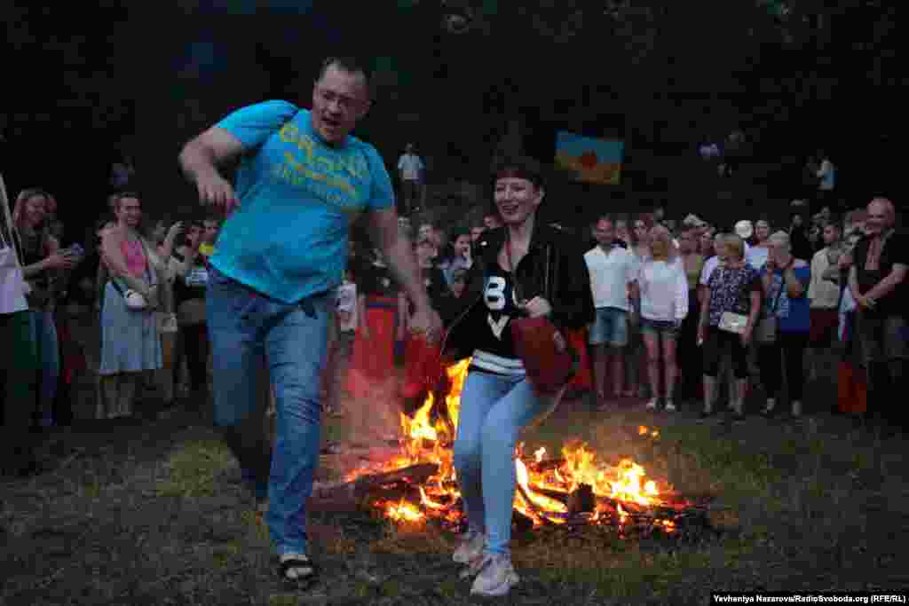 A couple jumps over the bonfire, a gesture said to help strengthen their bond.&nbsp;