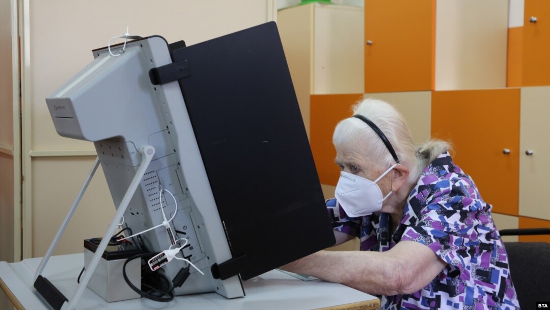 O femeie din Bulgaria în fața unei mașini de vot la alegerile parlamentare din 2021. Siguranța electronică a proceselor electorale contează din ce în ce mai mult în toată lumea în contextul intensificării atacurilor cibernetice.