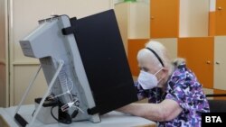 O femeie din Bulgaria în fața unei mașini de vot la alegerile parlamentare din 2021. Siguranța electronică a proceselor electorale contează din ce în ce mai mult în toată lumea în contextul intensificării atacurilor cibernetice.