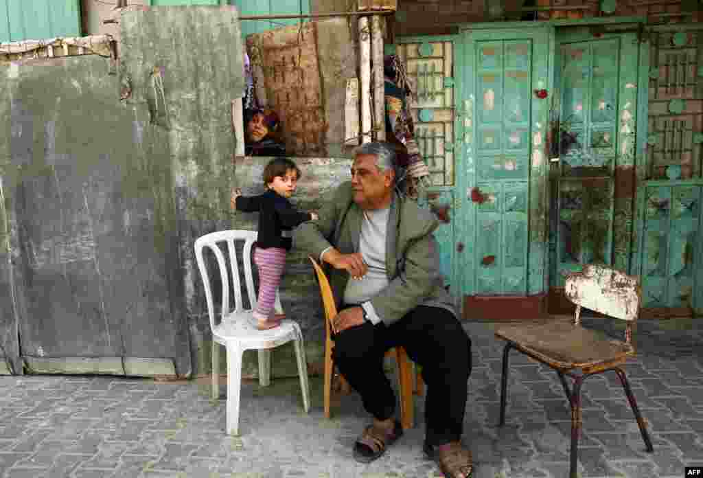 A Palestinian family sit outside their home in the Jabalia refugee camp in the northern Gaza Strip on April 6. (AFP/Mohammed Abed)