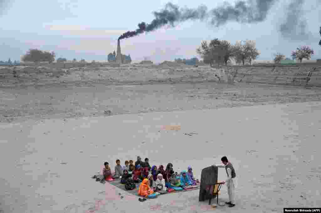 Afghan schoolchildren take lessons in an open classroom at a refugee camp on the outskirts of Jalalabad, Nangarhar Province. (AFP/Noorullah Shirzada)