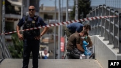 Greek police experts search for evidence outside AEK Athens' OPAP Arena on August 8 after a Greek fan was stabbed to death on the outskirts of Athens.