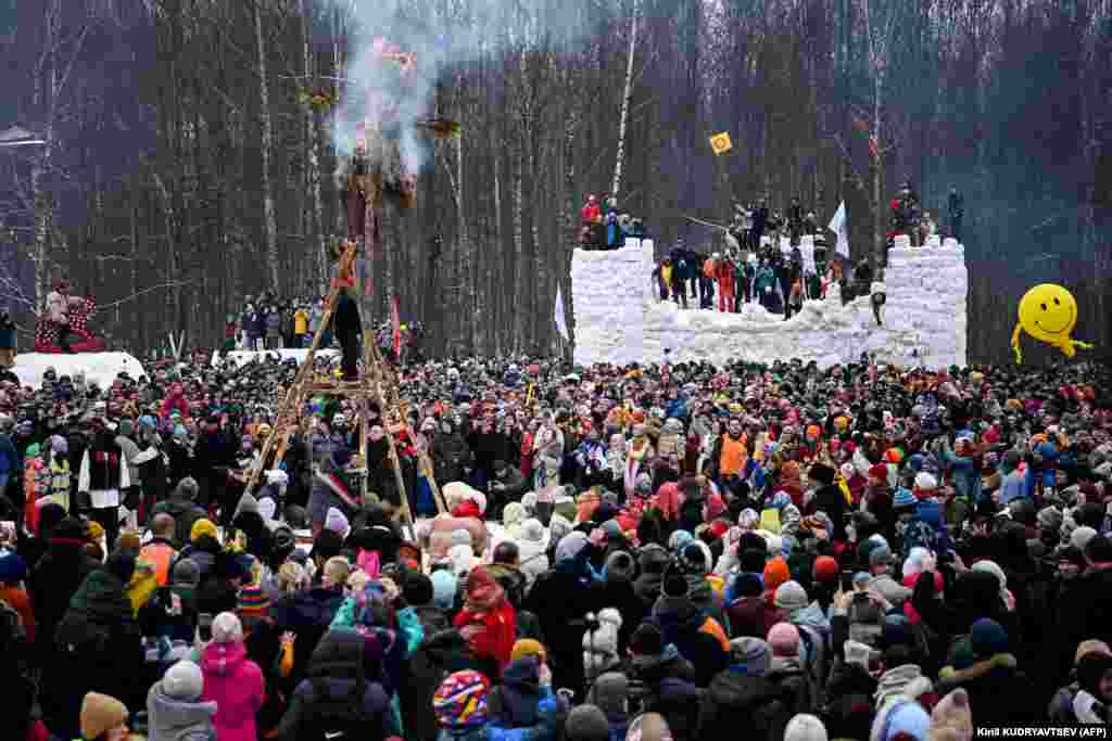 People burn a straw-wood-and-cloth effigy representing Mother Winter close to the village of Gzhel outside Moscow on March 14, as the part of celebration of Maslenitsa or Shrovetide, a farewell ceremony to winter. (AFP/Kirill Kudryavtsev)