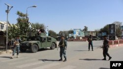 Afghan policeman stand alert during fighting between Taliban militants and Afghan security forces in Kunduz city on October 3.