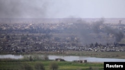 Smoke rises from a besieged village in Syria's Deir al-Zor Province in 2019. Iranian militias have a strong presence in the area and have long targeted the nearby al-Omar oil field, where the U.S. coalition has a major base.