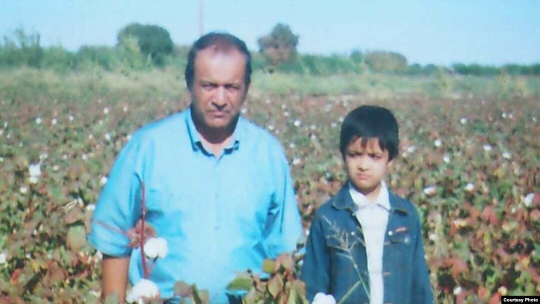 Yusuf Juma in a cotton field in Bukhara with his youngest son, in October 2004