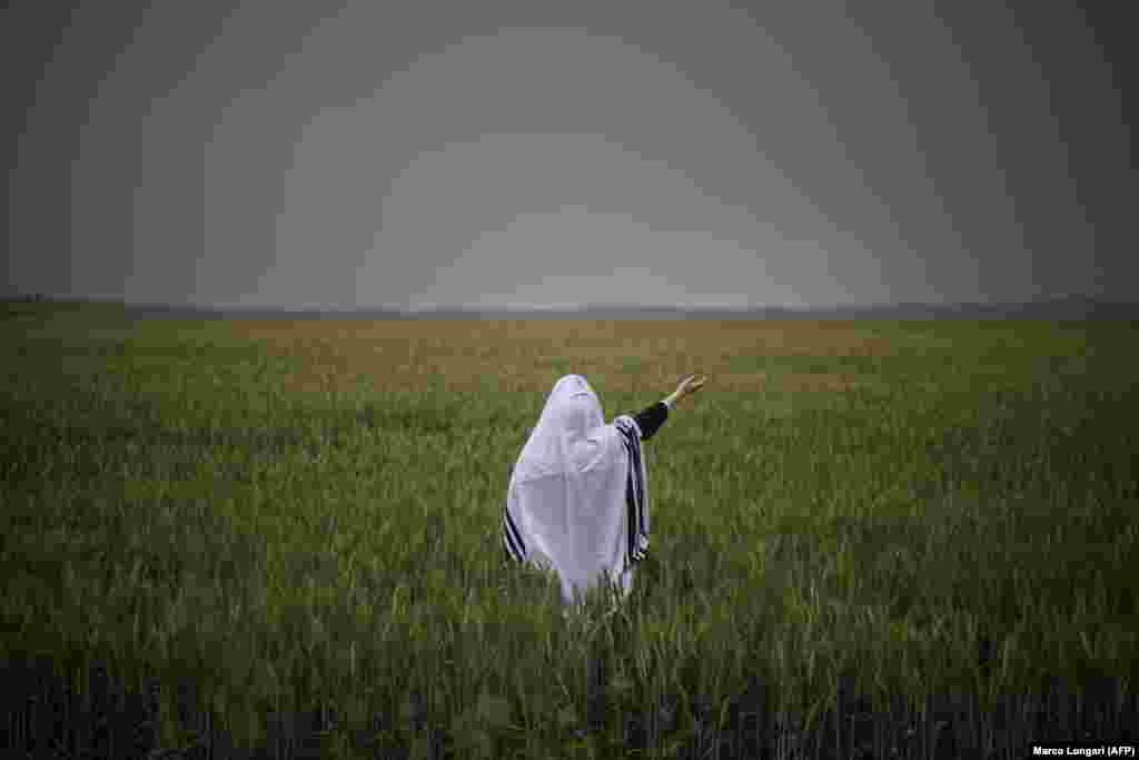 An orthodox Jewish man prays in a field in Latrun, Israel, as sirens warn of an incoming missile from Iran on April 1.