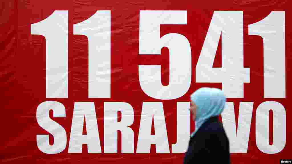 A Bosnian Muslim woman walks near a banner with the number 11,541 -- the number of Sarajevans killed in the 44-month siege.