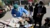 A health-care worker takes a nasal swab from a woman at a COVID-19 testing facility in Karachi. 