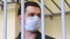 Trevor Reed stands inside a defendants' cage during a court hearing in Moscow in July 2020.