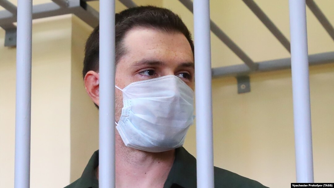 Trevor Reed stands inside a defendants' cage during a court hearing in Moscow in July 2020.
