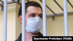 Trevor Reed stands inside a defendants' cage during a court hearing in Moscow in July 2020.