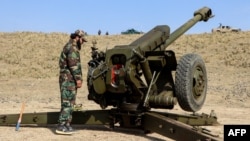 A Taliban fighter stands next to an artillery gun near Afghanistan's border with Pakistan on February 27.