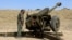 A Taliban fighter stands next to an artillery gun near Afghanistan's border with Pakistan on February 27.