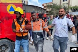 Un bărbat rănit după atacul de la Spitalul Nasser din Khan Yunis este transportat de salvatori.