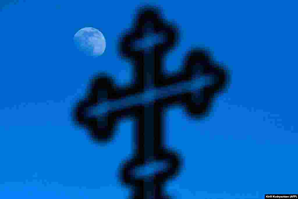 A daylight moon is seen behind a cross in Moscow. (AFP/Kirill Kudryavtsev)