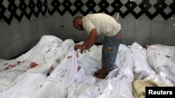 A man searches for bodies of his relatives who were supporters of ousted Egyptian President Muhammad Morsi after scores were killed in Cairo.