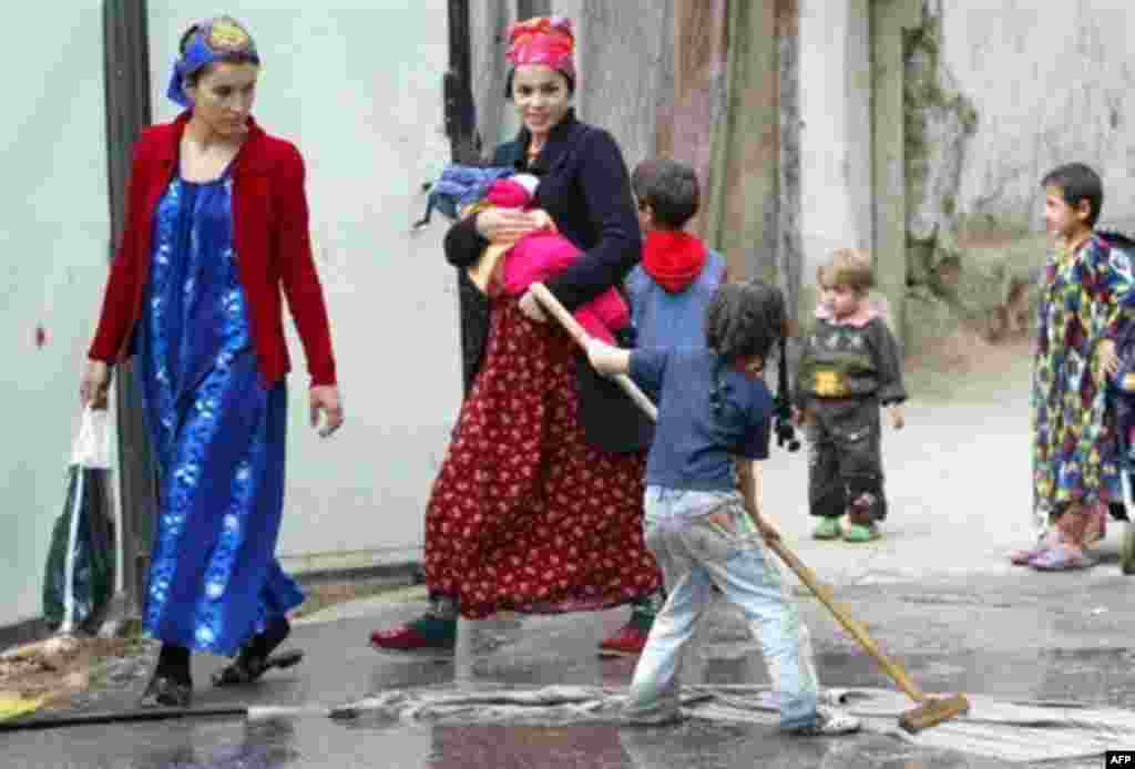 Tajikistan - A Tajik girl cleans a rug as two women pass by her in Dushanbe, 23Oct2006 - hgb01 TAJIKISTAN, Dushanbe : A Tajik girl cleans a rug as two women pass by her in Dushanbe, 23 October 2006. The post-Soviet nation now owes a total of $830 million to foreign creditors, including $510 million to international finance organizations such as the World Bank ($307 million), the Asian Development Bank ($100 million) and the Islamic Development Bank ($41 million)