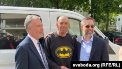 Президент ва мудири кулли РАО/РО Стивен Капус (аз чап), маҳбуси собиқ Иҳар Карней ва Ёвари котиби давлатии ИМА дар умури Аврупои Шарқӣ Кристофер Смитс пас аз раҳоии зиндониёни беларусӣ. 21 июни 2025