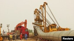 Workers set up a natural gas pipeline during a dust storm at Iraq's border with Iran in Basra, southeast of Baghdad, April 12, 2016. FILE photo