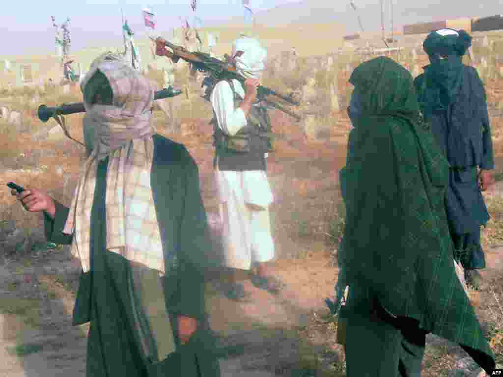 Taliban fighters stand at a cemetery, near the site where a CH-47 Chinook helicopter carrying U.S. troops crashed killing 38 personnel including 30 U.S. soldiers, at the remote Tangi Valley in Wardak Province, west of Kabul. Photo by AFP