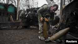 Ілюстраційне фото. Артилерист 152-ї окремої єгерської бригади ЗСУ готує снаряди для гаубиці, поки його побратими ведуть вогонь у бік російських військ поблизу Покровська, грудень 2025 року