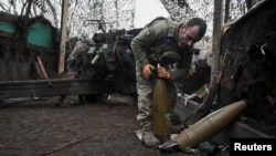 Артилерист 152-ї ОЄБр ЗСУ готує снаряди для гаубиці поблизу Покровська, Донецька область, 11 грудня 2025 року