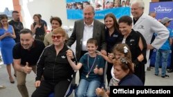 Armenia - British singer Elton John and Armenian President Armen Sarkissian pose for a photograph with children in Yerevan, 27 May 2018.