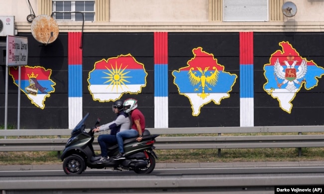 Dy persona shihen në një motoçikletë, e cila ka mbrapa hartat e Kosovës, Maqedonisë së Veriut, Bosnje-Hercegovinës dhe Malit të Zi, me flamuj të Serbisë në to. Beograd, gusht 2021.