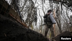 Артилерист 152-ї ОЄБр ЗСУ несе патрон до гаубиці після закінчення вогневої роботи в бік російських військ поблизу прифронтового міста Покровськ, Донецька область, 11 грудня 2025 року