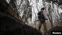 Артилерист 152-ї ОЄБр ЗСУ несе патрон до гаубиці після закінчення вогневої роботи в бік російських військ поблизу Покровська, Донецька область, 11 грудня 2025 року