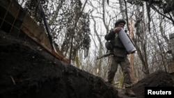 Ілюстраційне фото. Артилерист 152-ї ОЄБр ЗСУ несе патрон до гаубиці після закінчення вогневої роботи в бік російських військ поблизу прифронтового міста Покровськ, Донецька область, грудень 2025 року