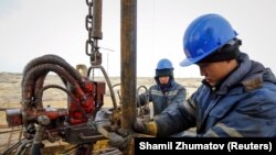 Workers in Kazakhstan do maintenance on an oil well. Low oil prices have brought sluggish growth and recession to the Caucasus and Central Asian economies.