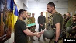 Ukrainian President Volodymyr Zelenskiy (left) visits troops near the front line in the Donetsk region on June 26. 