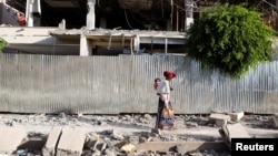 Žena prolazi pored ruševina zgrade oštećene u borbama u gradu Šir, region Tigraj. mart 2021. 