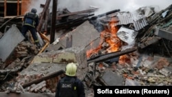 Firefighters work at the site of an apartment building hit by a Russian air strike, amid Russia's attack on Ukraine, in Kharkiv, Ukraine, on January 2.