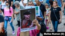Протестиращ в Русе държи плакат с лика на депутата от ДПС Делян Пеевски и надпис "Кралят Слънце".