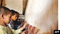 Afghan boys work on a carpet in Kabul.