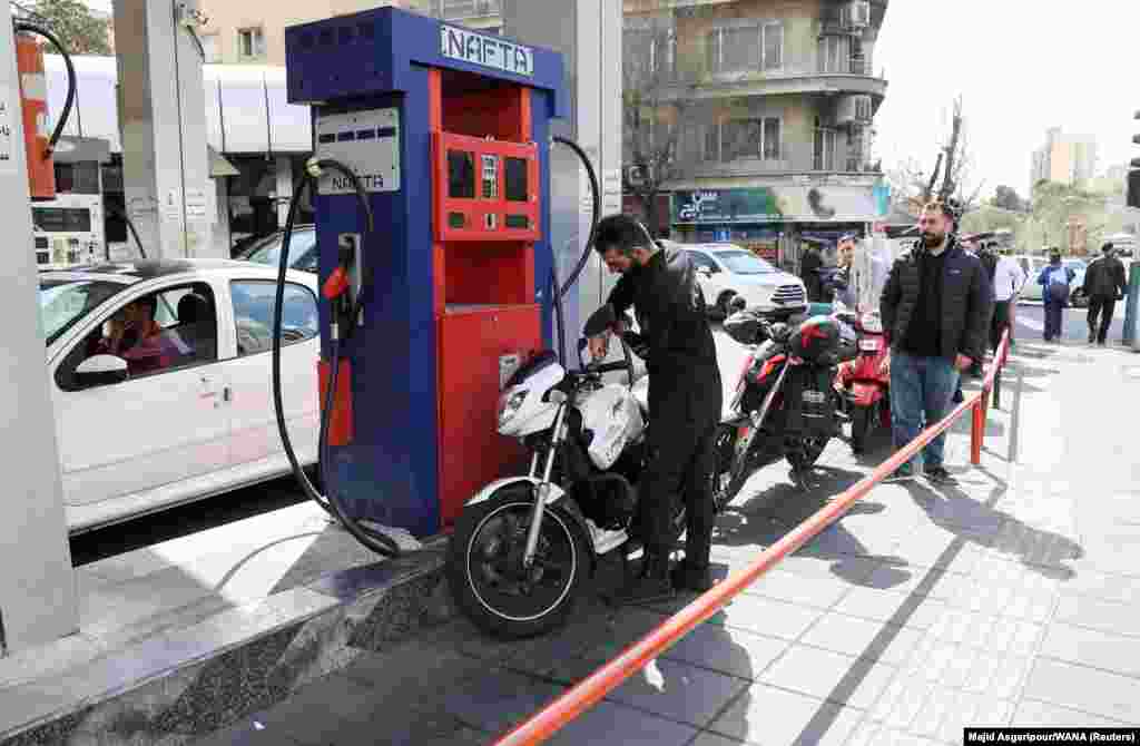 A man fills up his vehicle at a fuel station in Tehran.